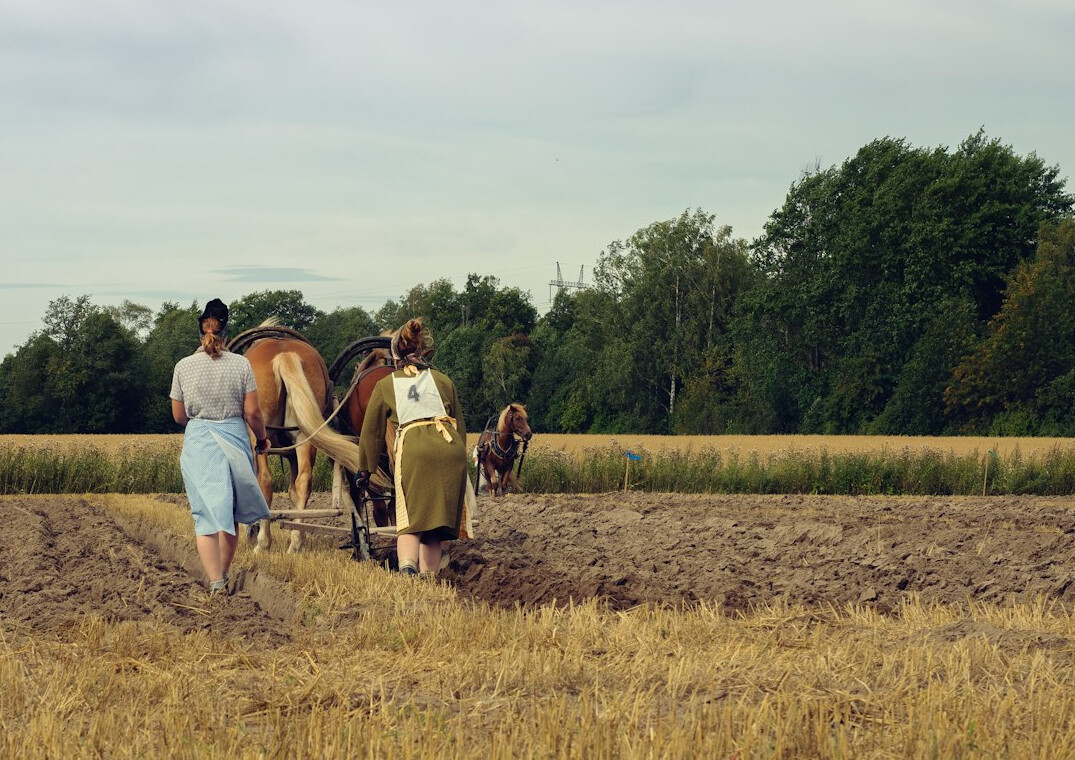 Three generations of a Danish farming family standing together in a field